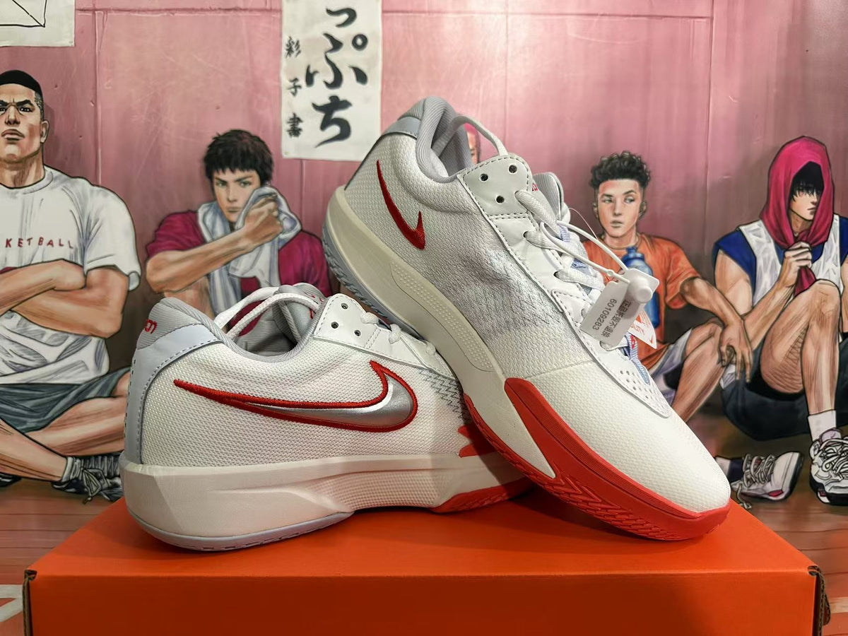 Angled view of white and red Nike basketball shoes showing the side panels and outsole.
