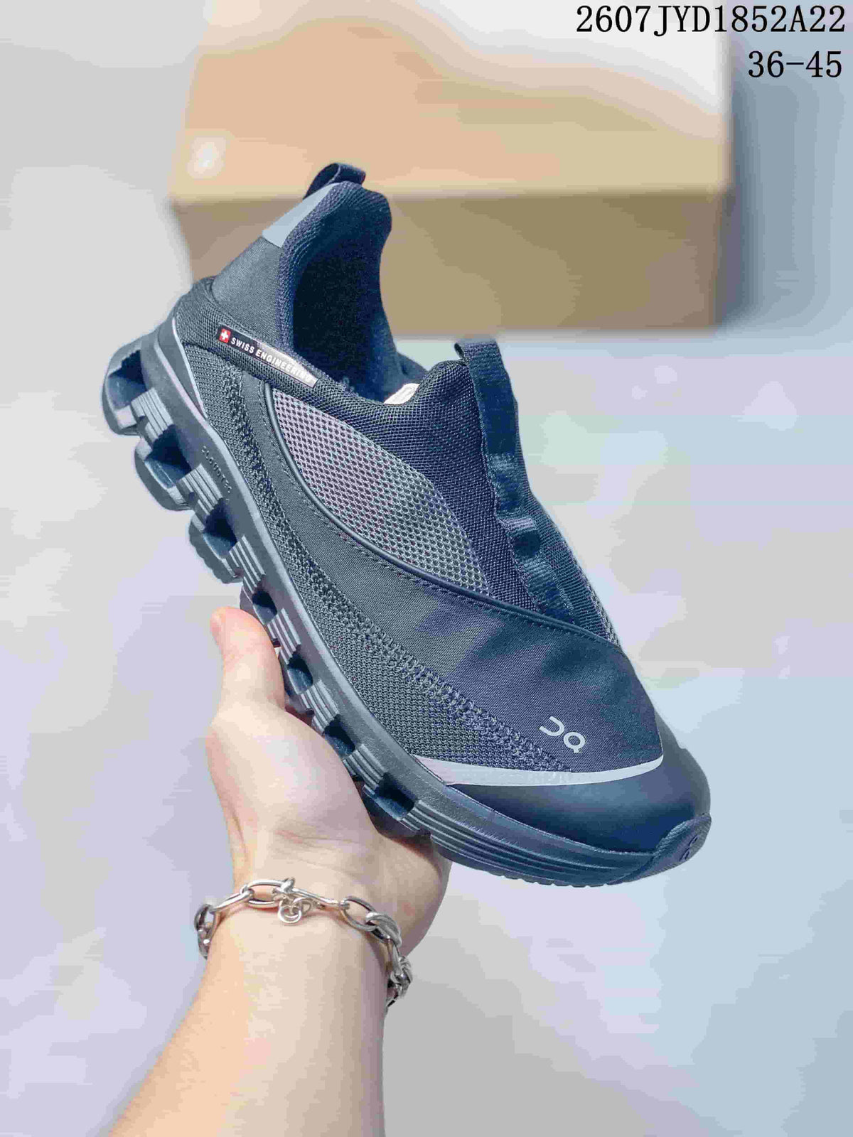 Angled side view of a black On sneaker showing the mesh upper, On logo and segmented sole.