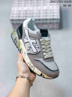 Angled side view of the grey and white Premiata sneaker showing the layered panels, cream laces and printed midsole.