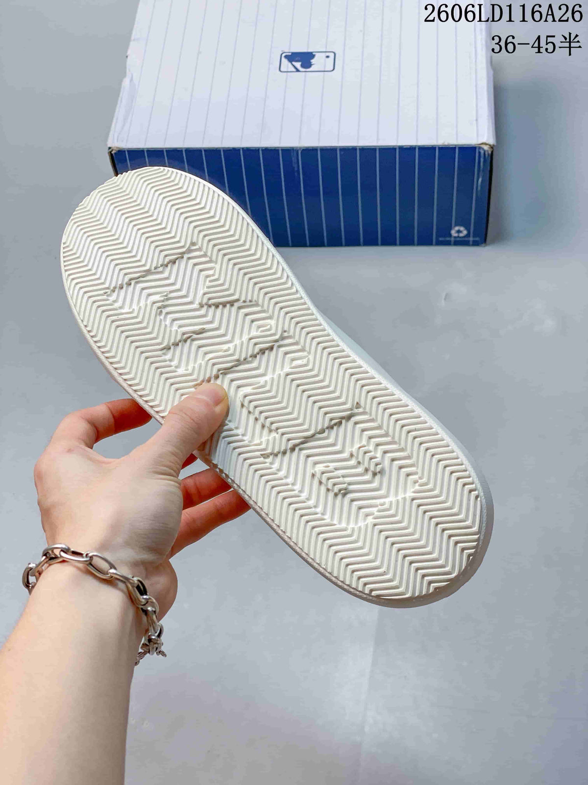Close-up of the white sneaker outsole showing a zigzag tread pattern.