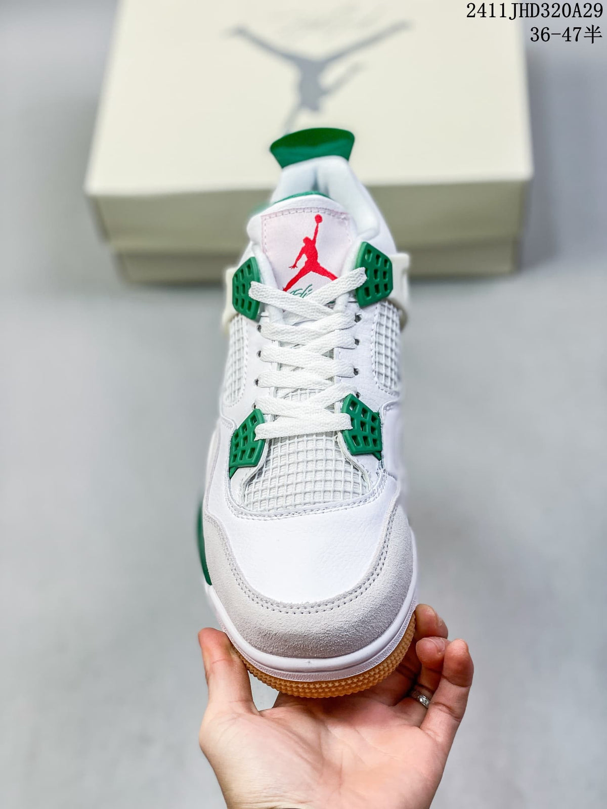 Front view of a white high-top sneaker with green lace supports, mesh panels, white laces, and red tongue branding.