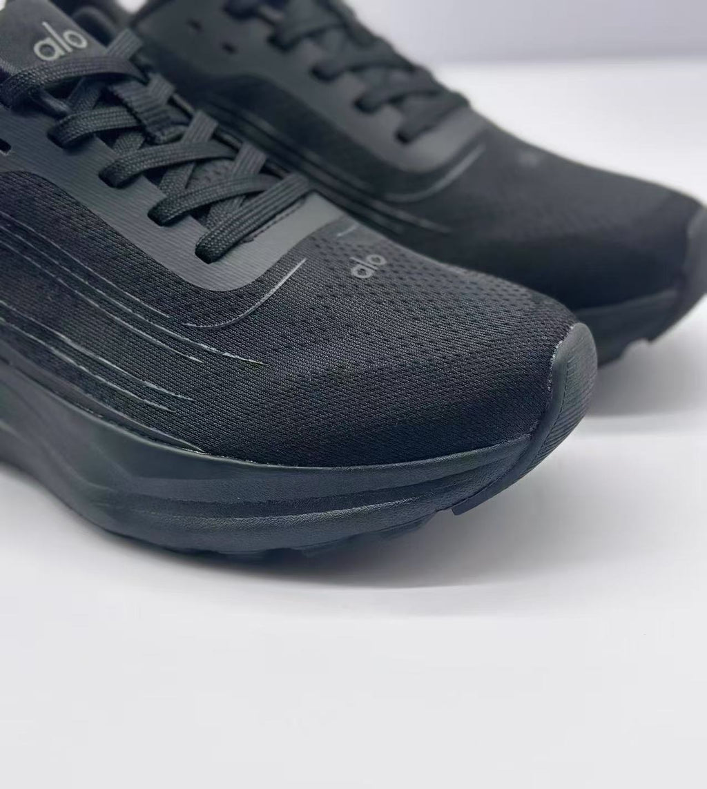Close-up of the black textured toe and lace area with tonal Alo branding and layered stitching details.