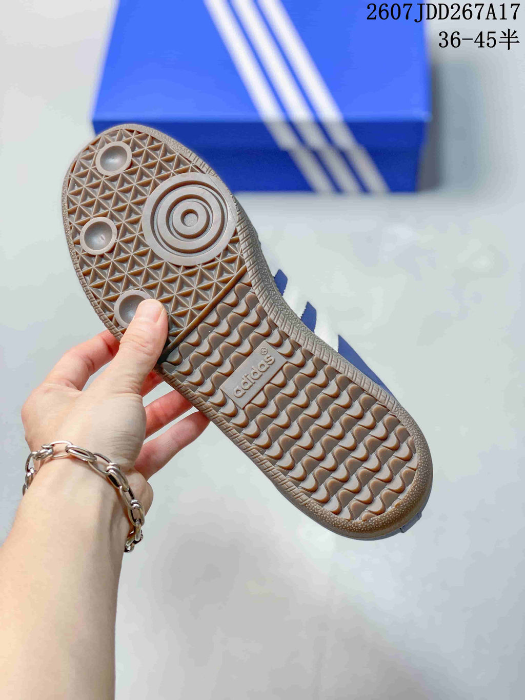Underside view of the sneaker showing the gum-colored rubber outsole and geometric tread pattern.