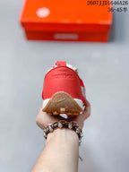 Rear view of the red sneaker showing Jacquemus branding on the heel and the textured gum outsole.