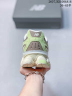 Rear view of the sneaker showing the green heel panels, gray perforated detail, layered cream midsole, and white collar.