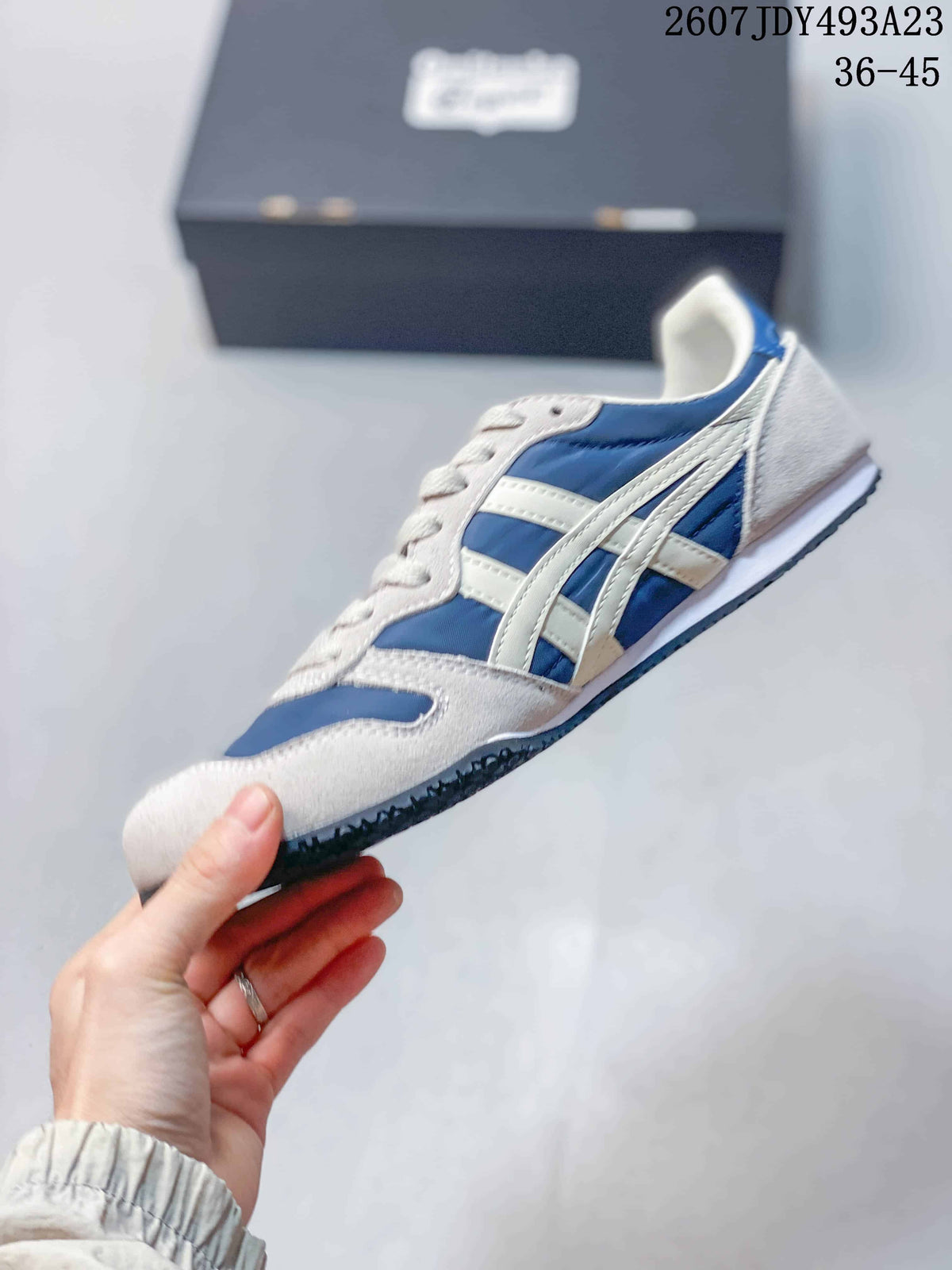 Side profile of the blue and white sneaker showing the layered contrasting side stripes, lace-up upper and low-profile sole.