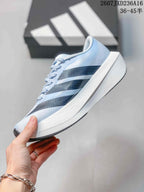 Side profile of the light blue running shoe showing three patterned dark side stripes and a raised white midsole.