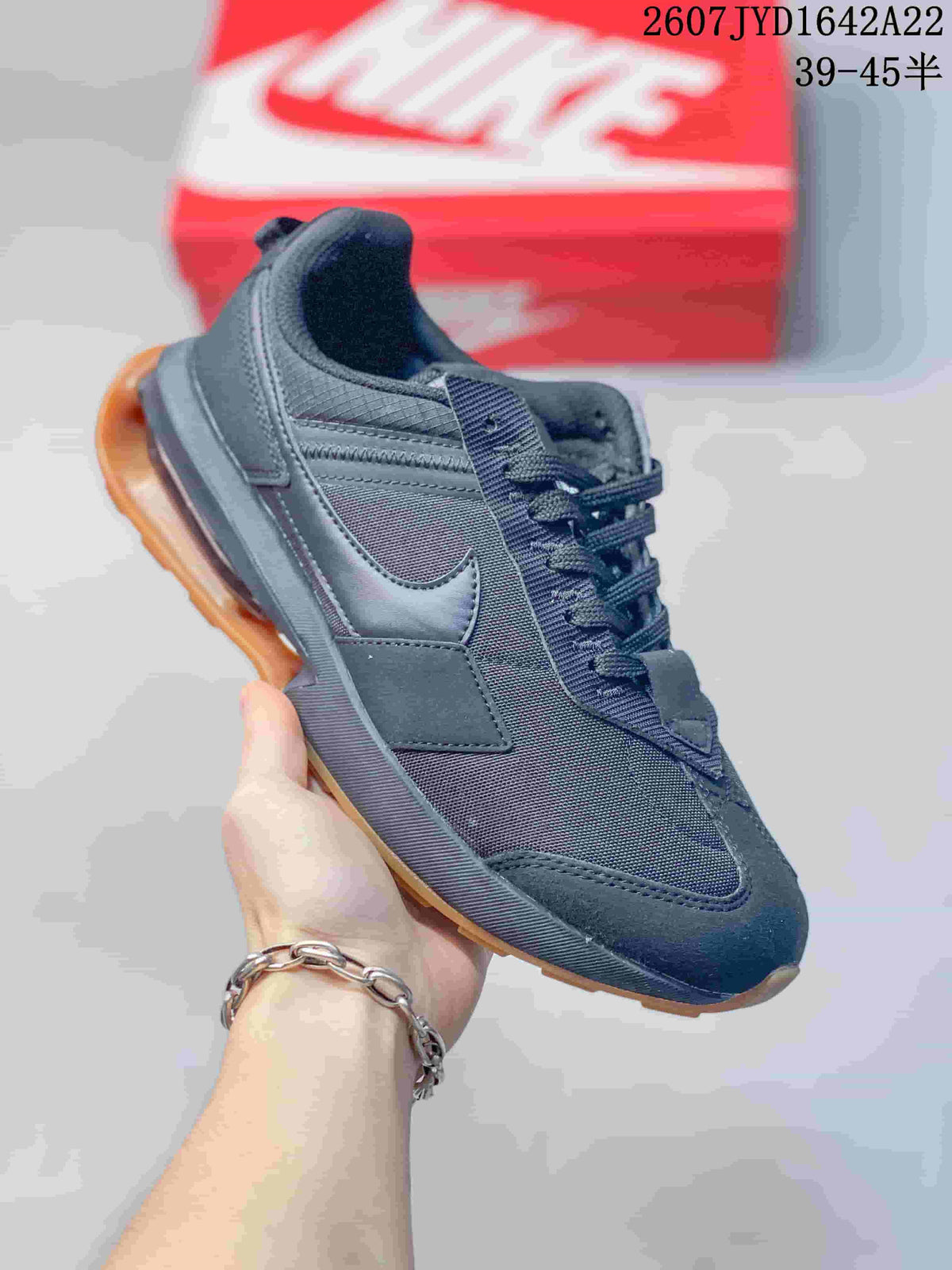 Angled side view of the black Nike sneaker highlighting the mesh-like upper, side branding and gum-colored outsole.