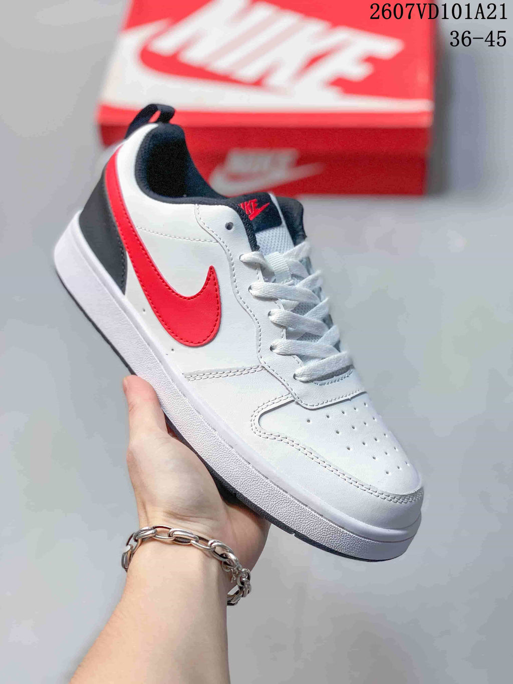 White Nike Court Borough BG sneaker with red and black accents, shown from the side.