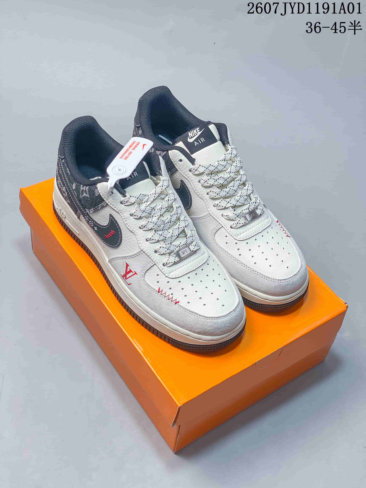 Pair of white and gray low-top sneakers with dark patterned panels on an orange box