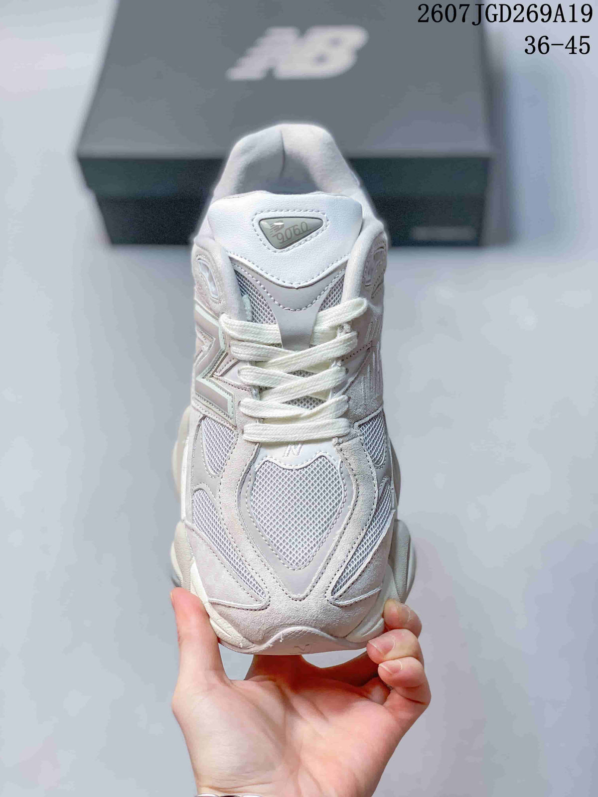 Top view of a light white New Balance 9060 sneaker showing the mesh toe area, layered overlays, laces and 9060 tongue label.