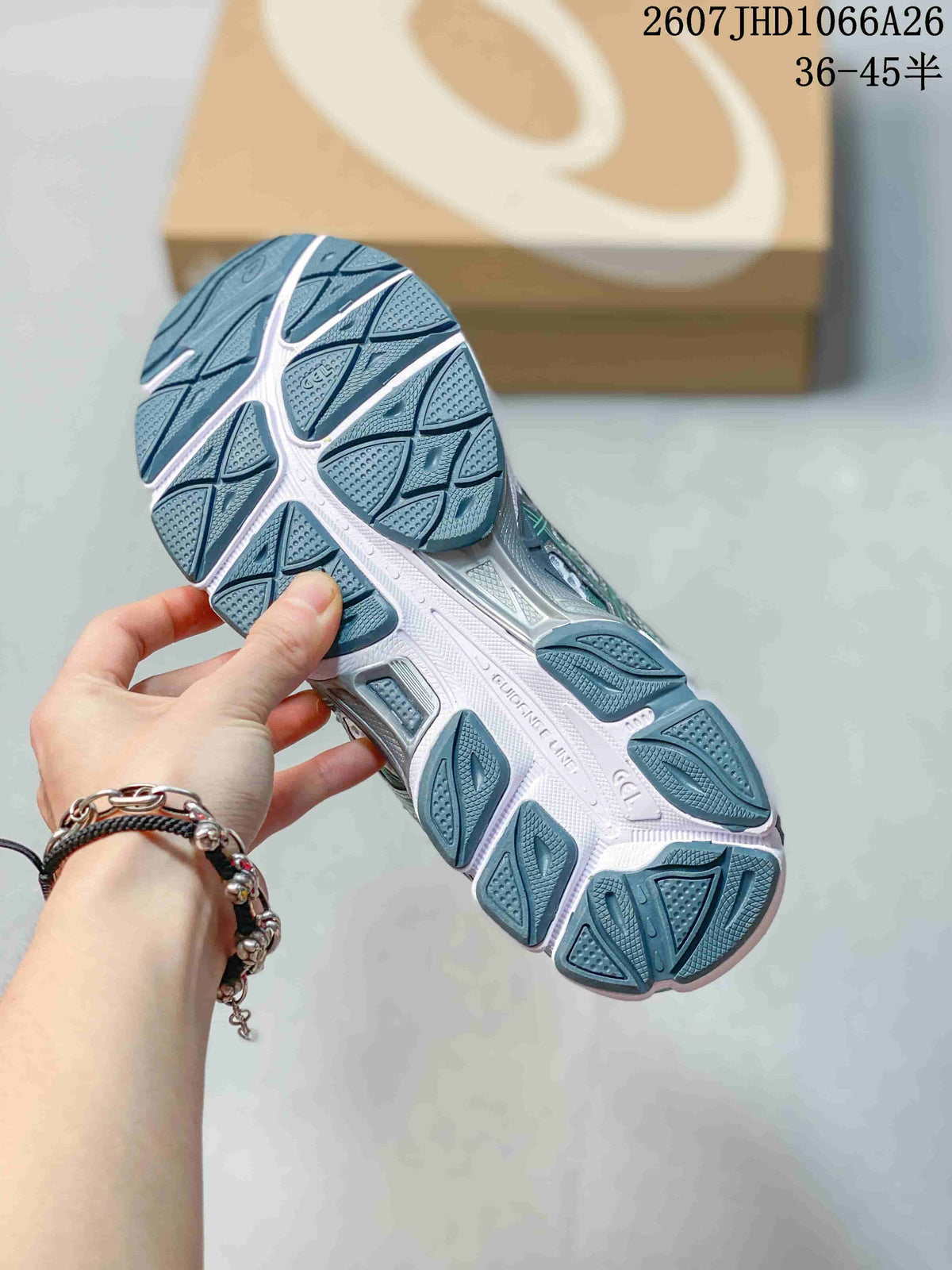 Close-up of the textured outsole on an ASICS Gel-Cumulus 16 sneaker, showing segmented tread blocks and a white midsole.