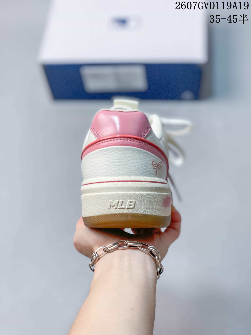 Rear view of the white and pink sneaker showing the pink heel panel, layered heel trim, bow detail and raised MLB branding on the midsole.