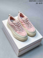 Pair of pink and white Moncler Pacey low-top sneakers displayed on a shoebox.