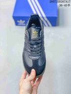 Top view of the black lace-up sneaker showing the tongue branding, rounded toe and glitter-style side detailing.