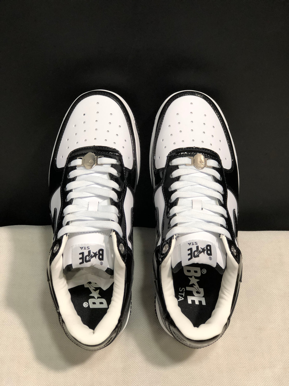Top-down view showing white perforated toe panels, white laces, tongue branding and padded collars.