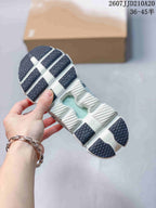 Outsole view showing the segmented white sole and dark textured traction sections.