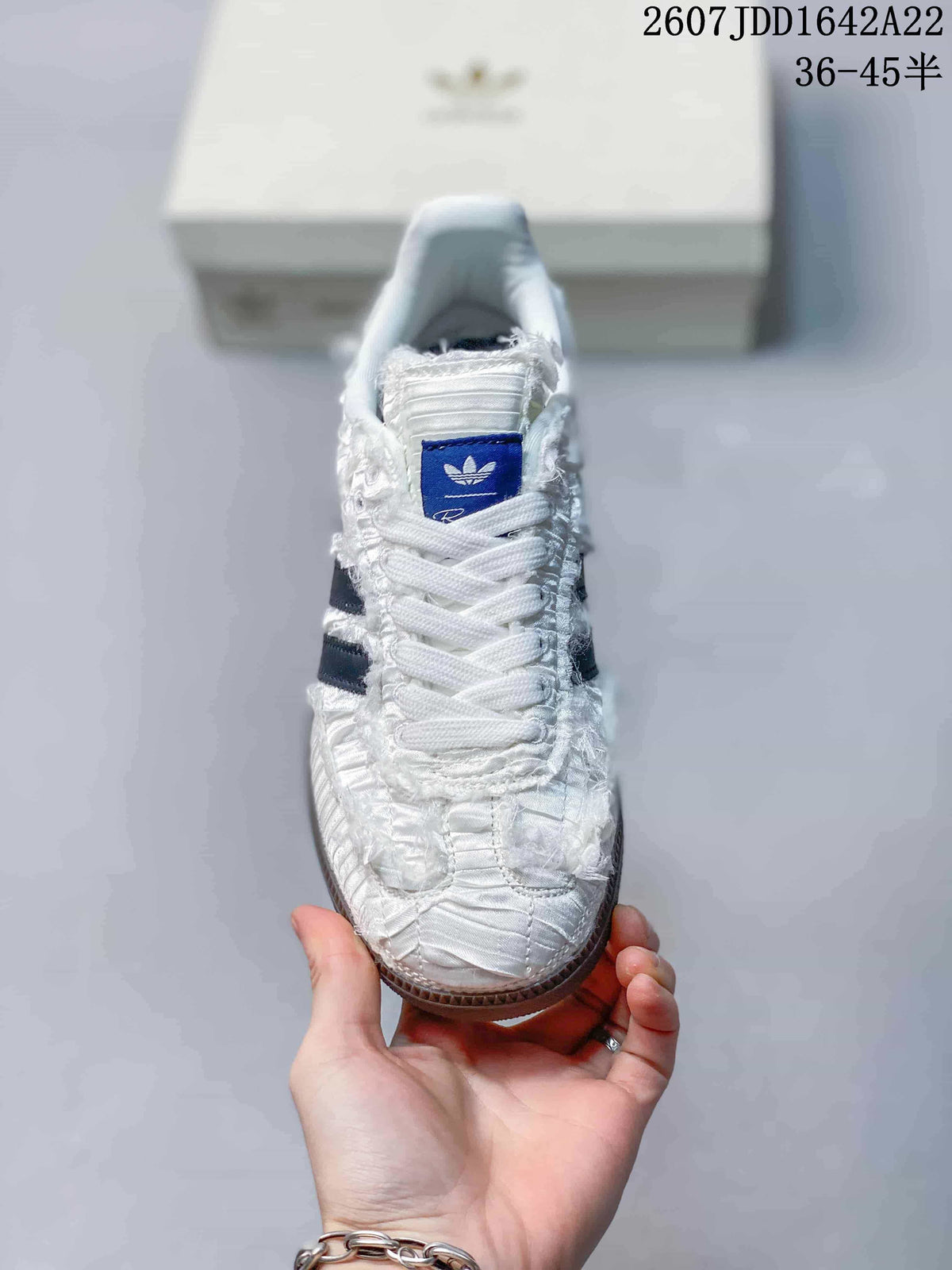 Front view highlighting the textured white toe, laces, and blue adidas tongue label.