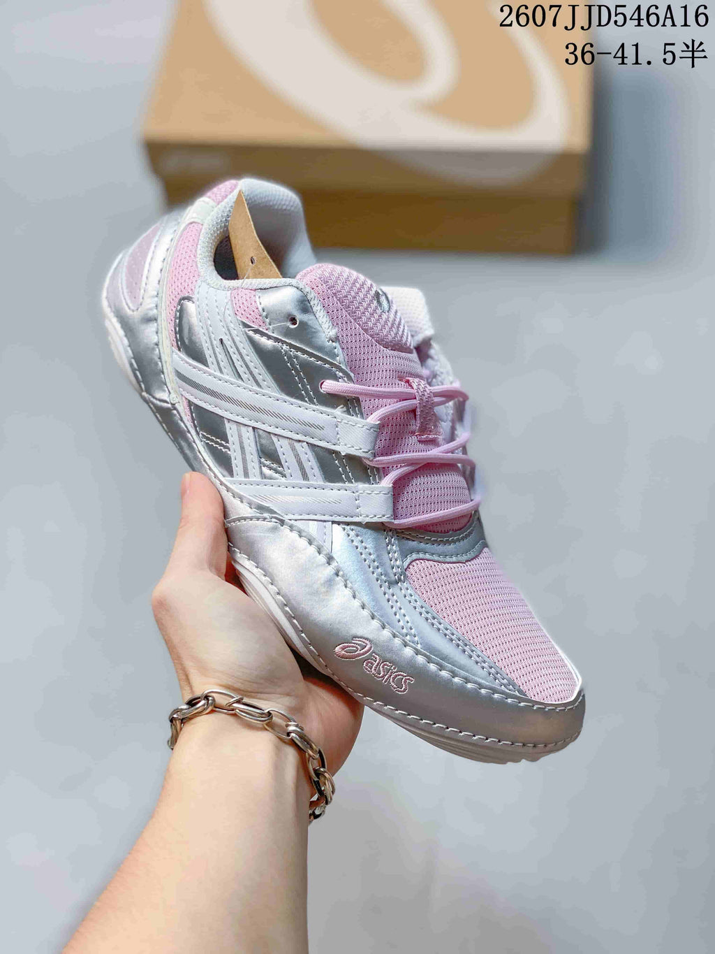 Angled side view of the silver and pink ASICS Hypersync sneaker with visible branding and layered upper details.