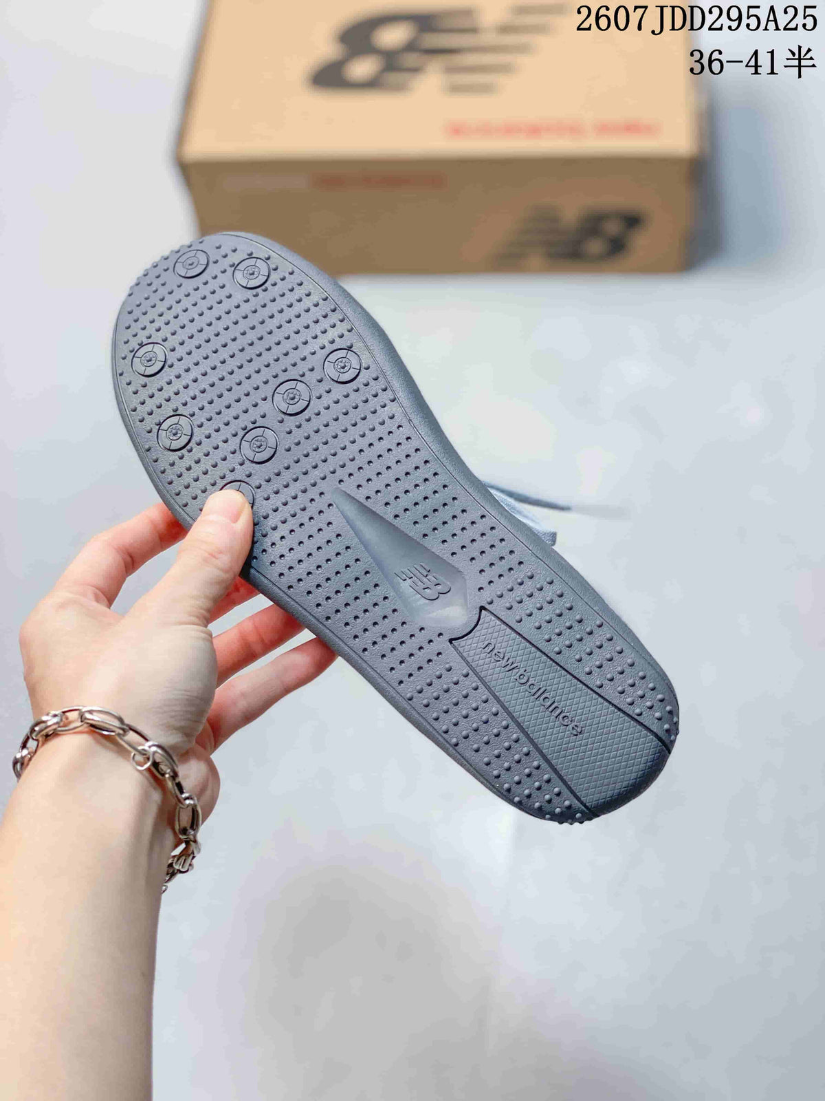 Close-up of the textured dark outsole with circular traction details and New Balance branding.