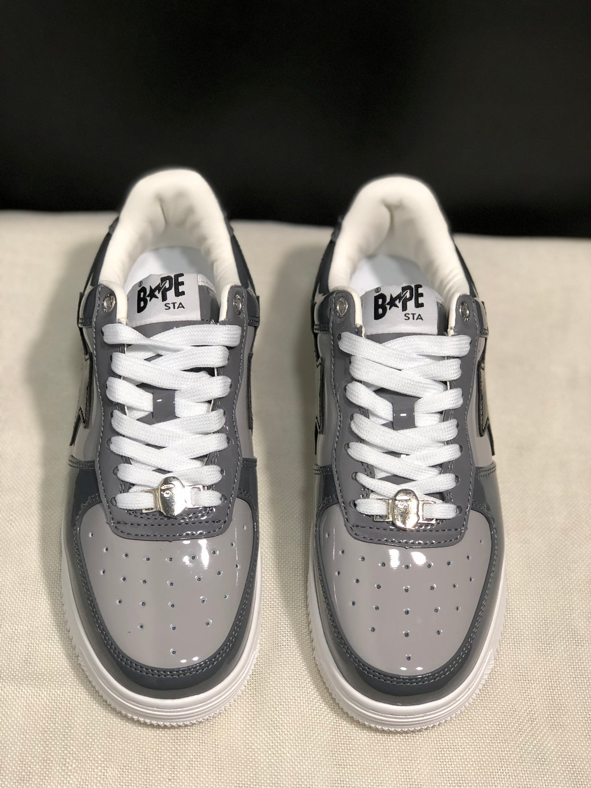 Front view showing the gray perforated toe boxes, white laces, and metallic lace hardware.