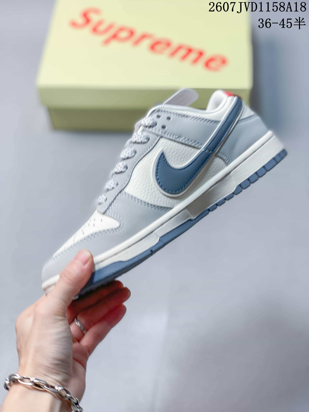 Side profile showing the low-top shape, layered gray and white panels, dark gray side logo, and contrasting sole.