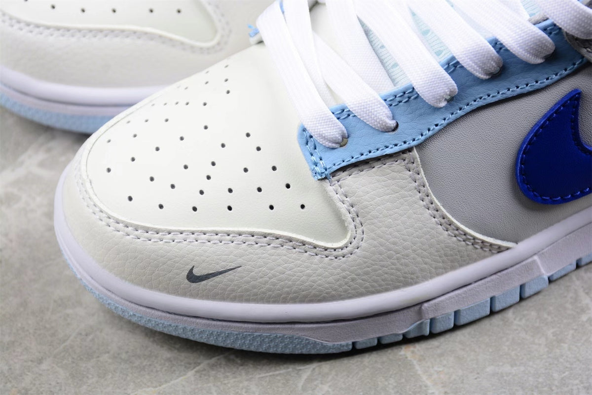 Close-up of the perforated white toe box, gray overlay, and light blue outsole edge.