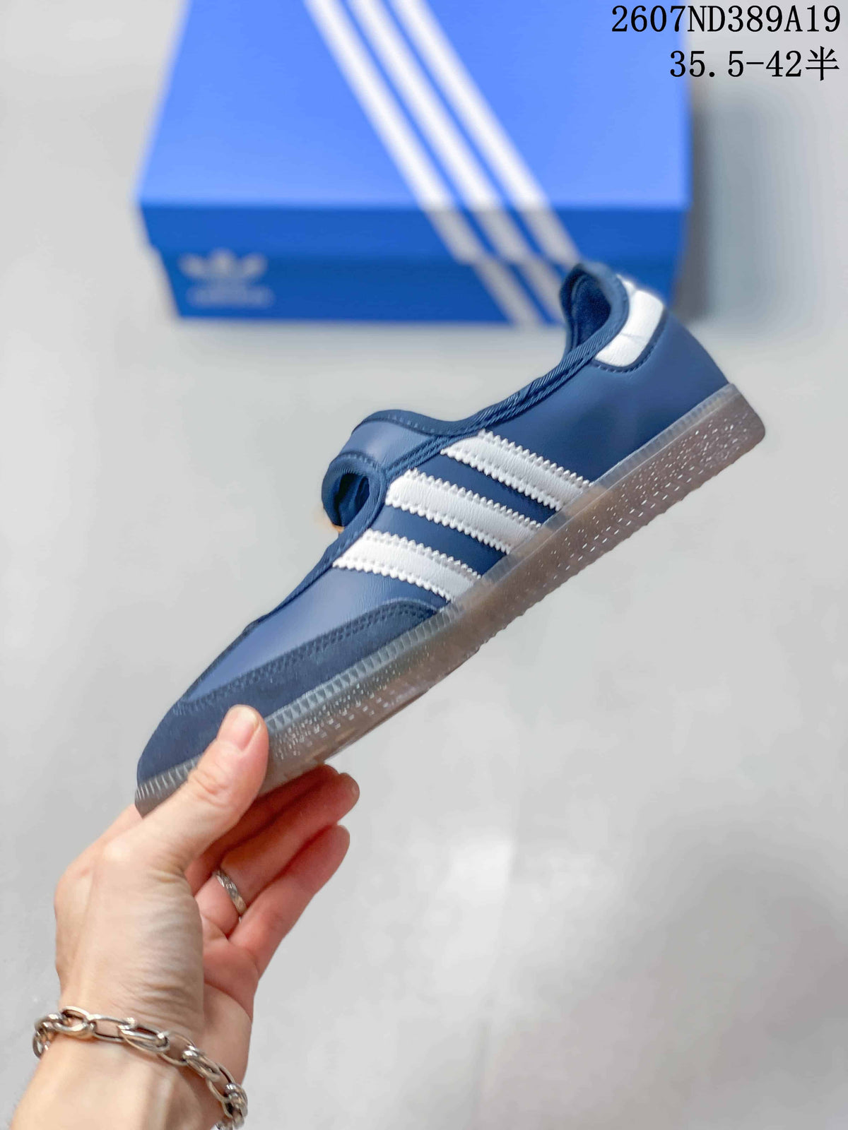 Side view of the blue and white sneaker showing the three white stripes, low-profile shape, and gum-style outsole.