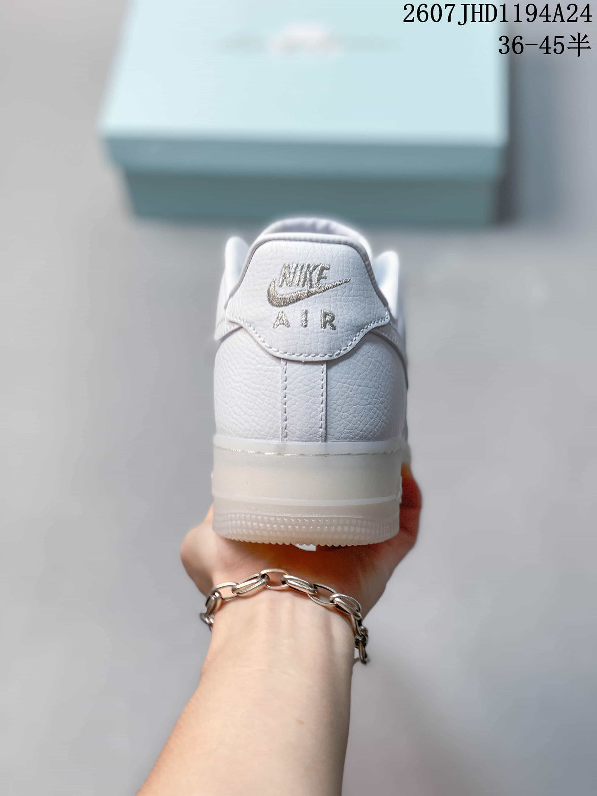 Rear view of the white sneaker showing embroidered Nike Air branding on the heel.