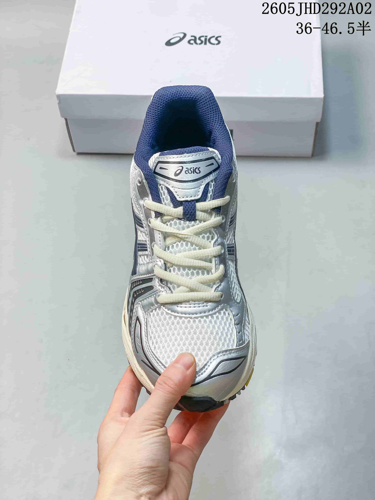 Front view of the sneaker showing its laces, mesh-style panels, and silver-toned details