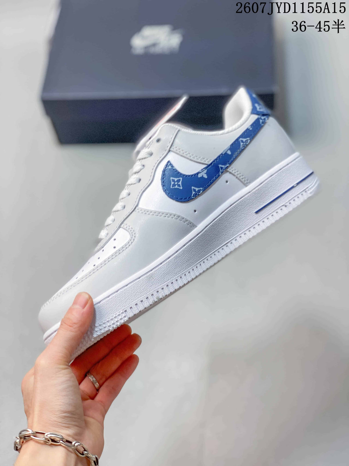 Side view showing the blue patterned Swoosh, white upper, and layered white sole.