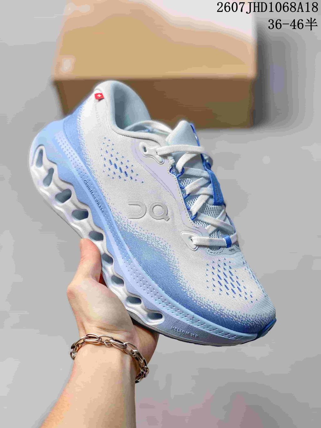 Blue and white On Cloudsurfer 3 sneaker with a sculpted white outsole and visible source size range text.