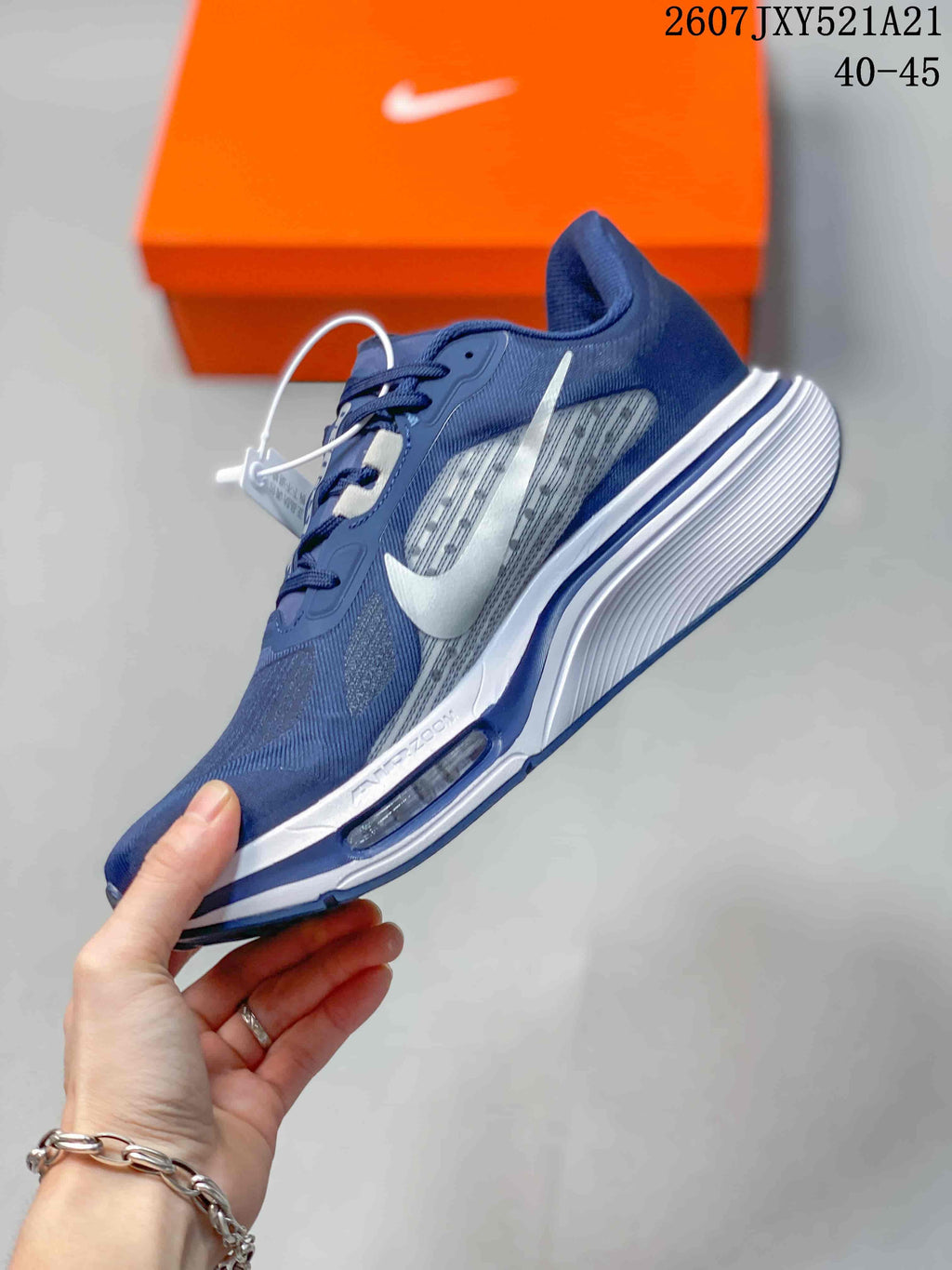 Side view of the navy sneaker showing the white Swoosh, layered upper panels, and white midsole.
