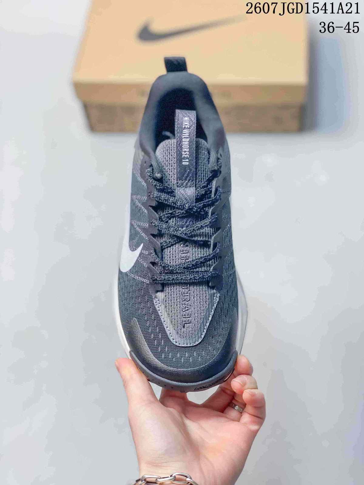 Top view of the sneaker showing the dark gray mesh-like upper, laces, tongue branding, and contrasting toe details.