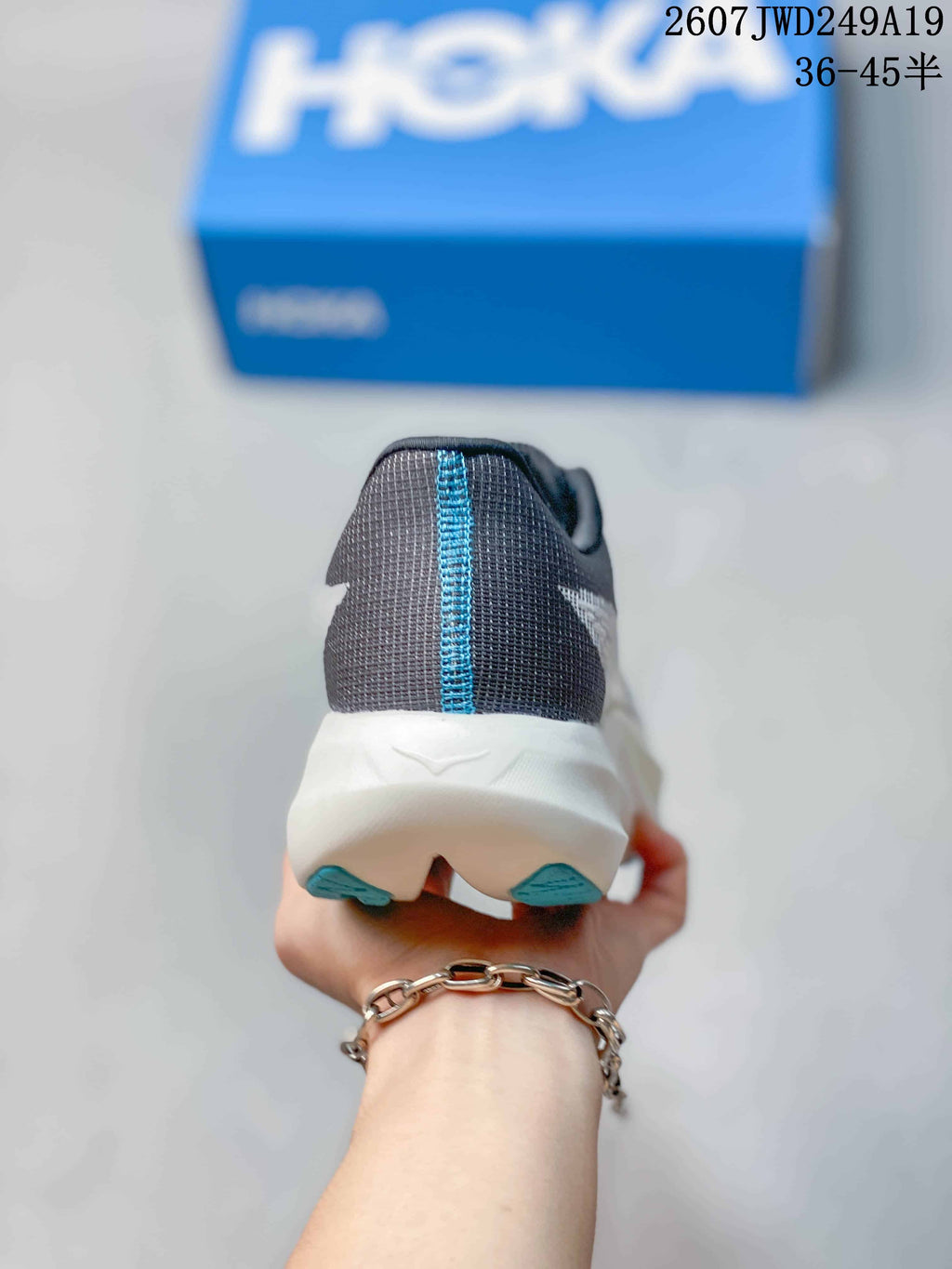 Rear view of the sneaker showing the dark mesh heel, blue vertical seam detail, white midsole, and blue outsole accents.