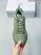 Top view of the green sneaker showing the patterned upper, tongue, quick-lacing system, and toggle detail.