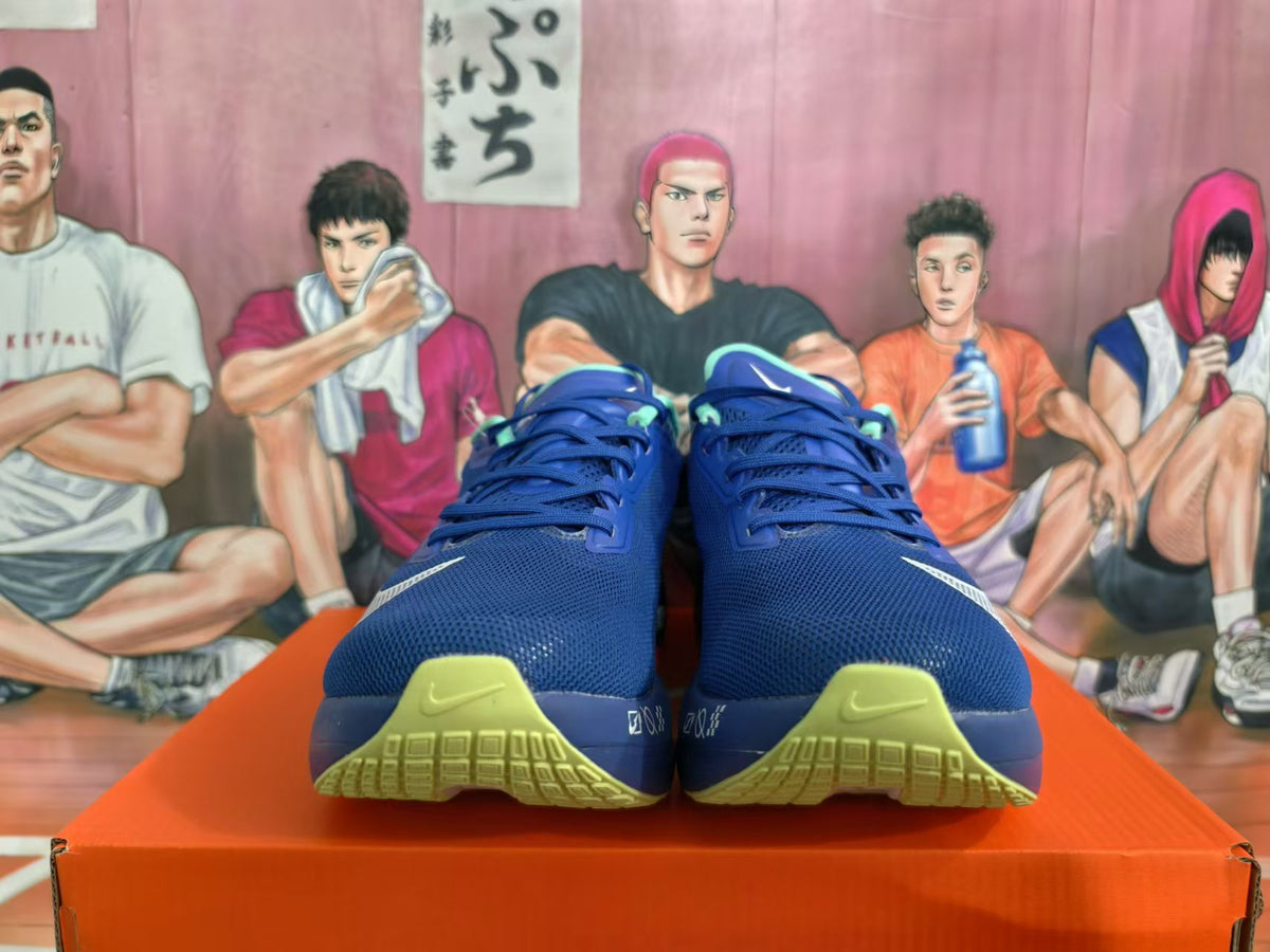 Front view of blue Nike running shoes with mint accents and yellow-green outsole details.