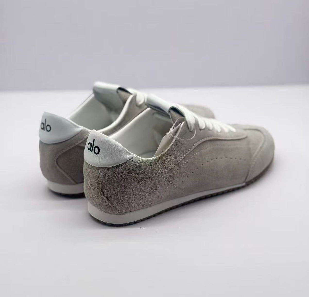 Rear three-quarter view showing the gray heel panels and white Alo-branded heel details.