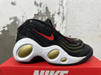 Side view of a black Nike Flight sneaker with a red Swoosh and sculpted white midsole with gold-colored inserts.