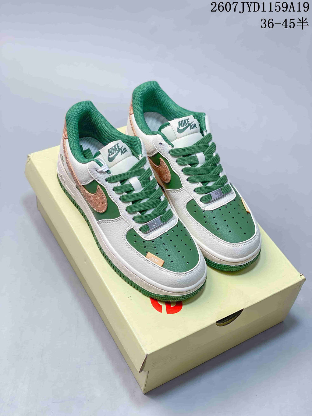 Pair of white, green and tan Nike Air Force 1 '07 low-top sneakers displayed on a shoebox.