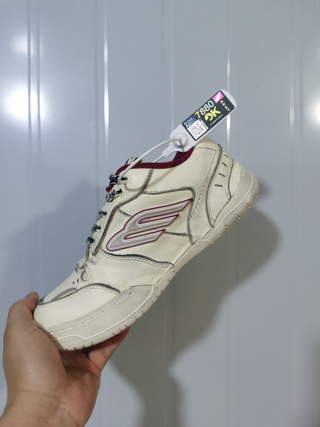 Close angled view of the Balenciaga Hamptons sneaker highlighting the side logo, red collar and textured outsole.