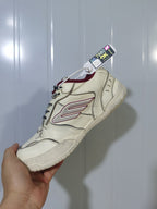 Close angled view of the Balenciaga Hamptons sneaker highlighting the side logo, red collar and textured outsole.