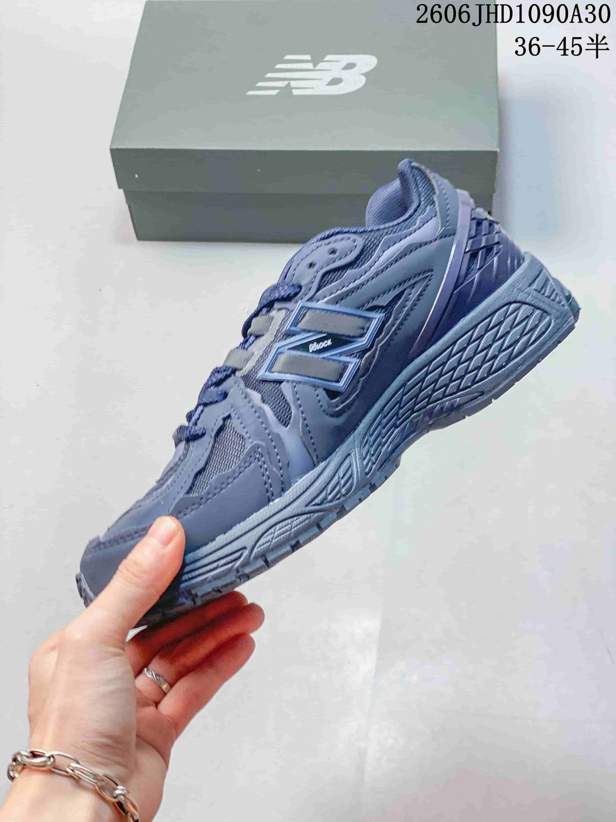 Side view of a blue-gray New Balance M1906RA sneaker with layered panels and a sculpted sole.
