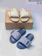 Blue and beige Louis Vuitton Pool Pillow monogram slides shown together from above on a patterned box.