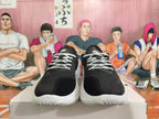 Front view showing black toes, patterned white laces, and white soles.