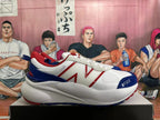 Side view of a white New Balance sneaker with red logo detailing, navy overlays, and a chunky sole.