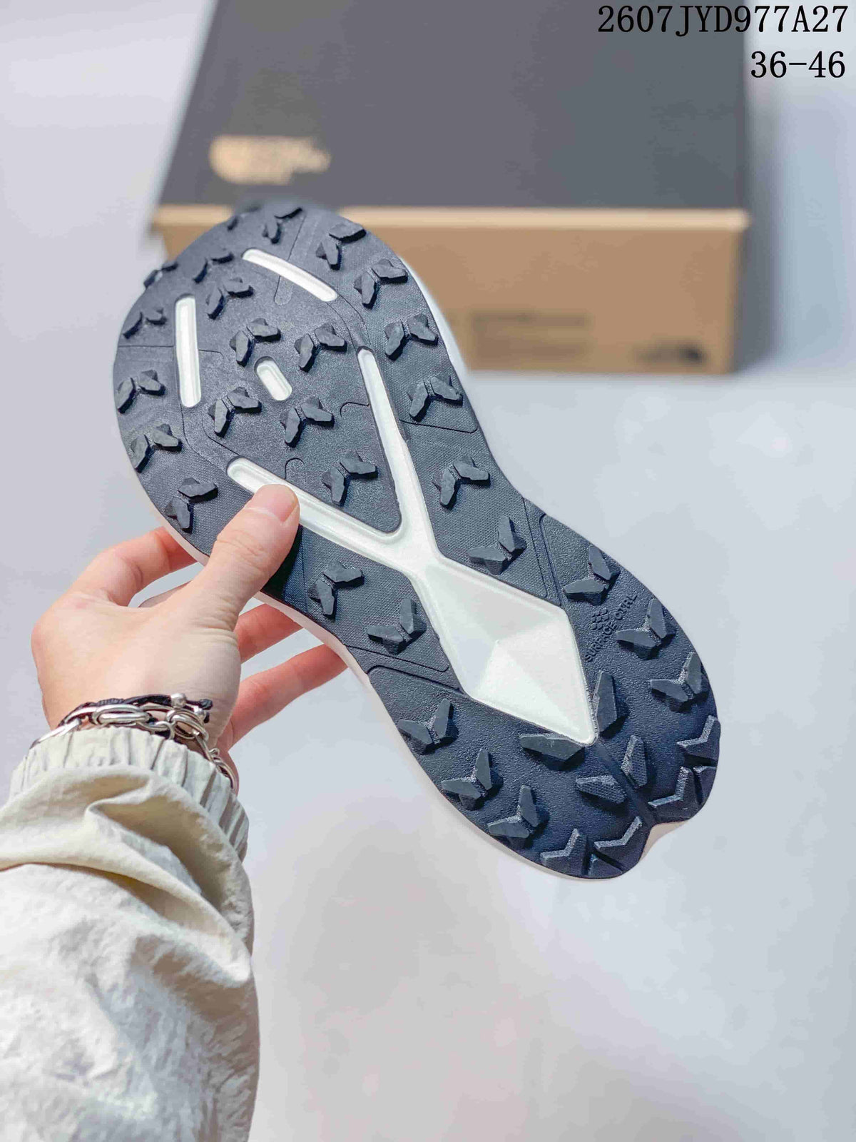 Close-up of the dark lugged outsole showing the trail-oriented tread pattern.