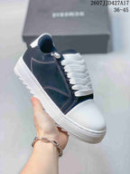 Angled side view of a navy and white Numeris sneaker showing the white toe cap, contrast stitching, laces, and outsole.