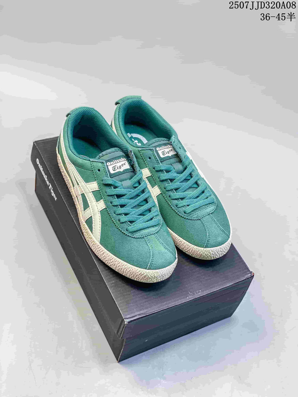 Pair of green and cream low-top sneakers displayed on a black shoebox.