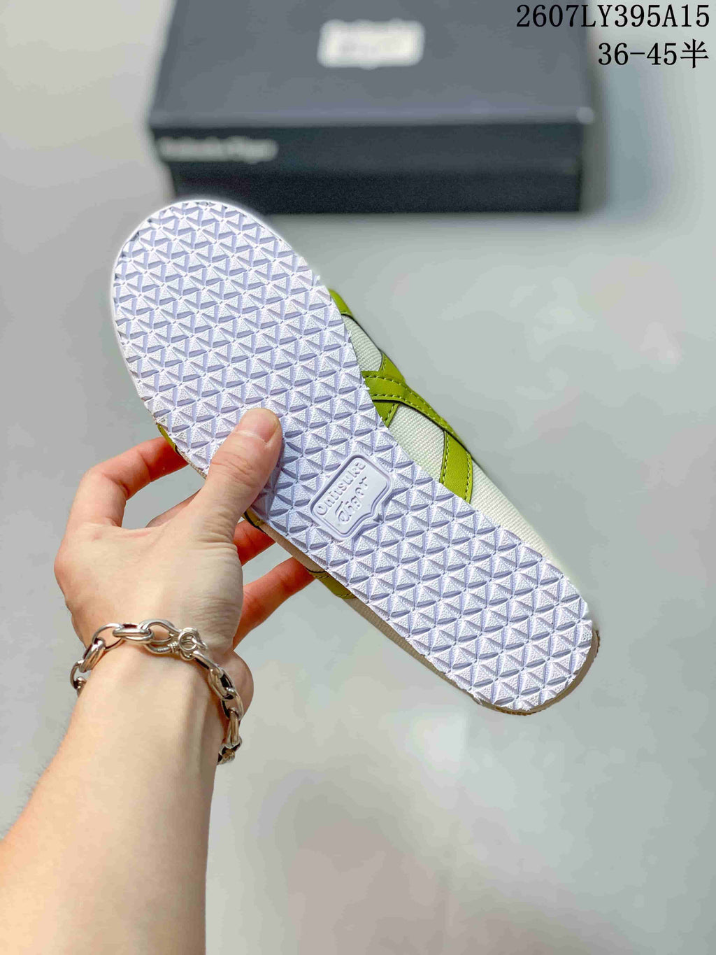 Bottom view of the sneaker showing the repeating geometric tread pattern on the rubber outsole.